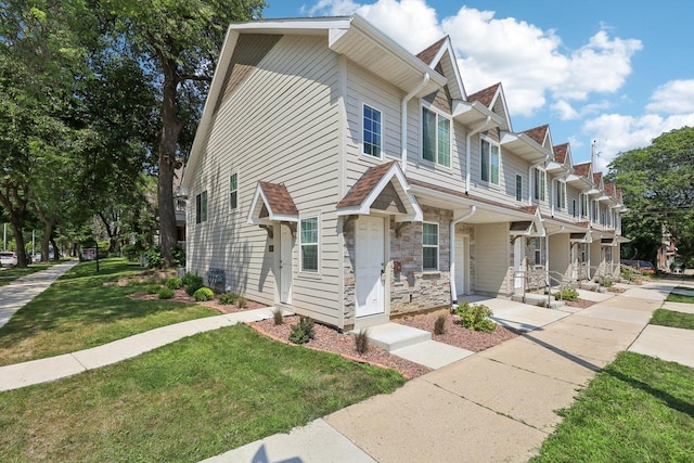 townhome / multi-family property with a front lawn and covered porch