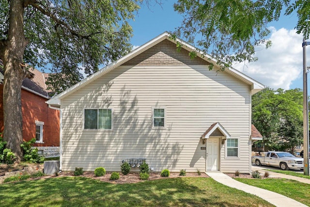 view of side of home featuring a lawn and central AC