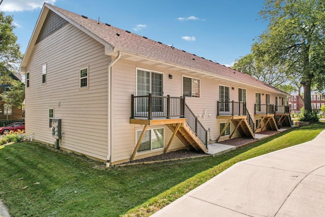 rear view of house featuring a lawn and a deck