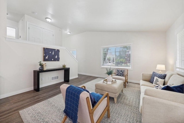 living room with lofted ceiling, a healthy amount of sunlight, and dark hardwood / wood-style floors