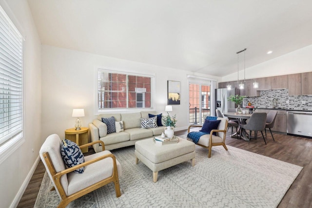 living room with sink, vaulted ceiling, and light hardwood / wood-style floors