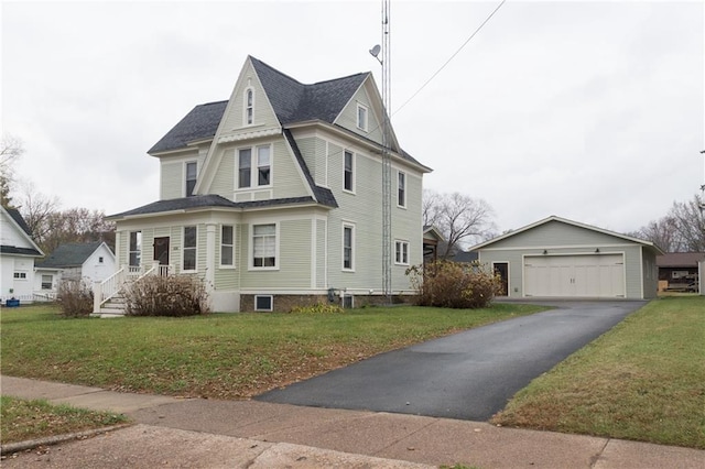 view of front facade featuring a garage, an outdoor structure, and a front lawn