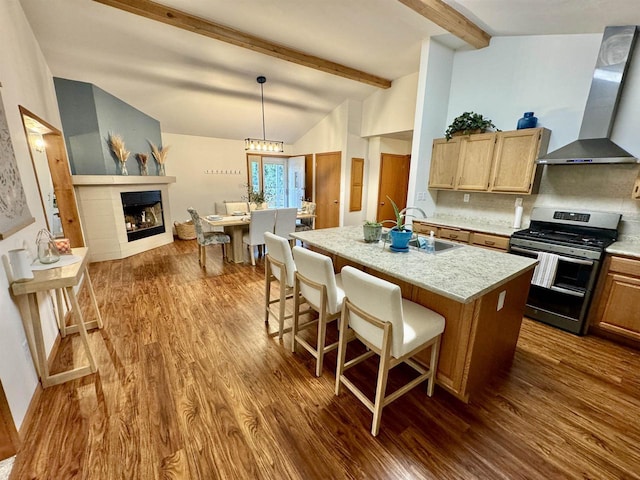 kitchen featuring lofted ceiling with beams, tasteful backsplash, stainless steel gas range, dark hardwood / wood-style flooring, and wall chimney exhaust hood