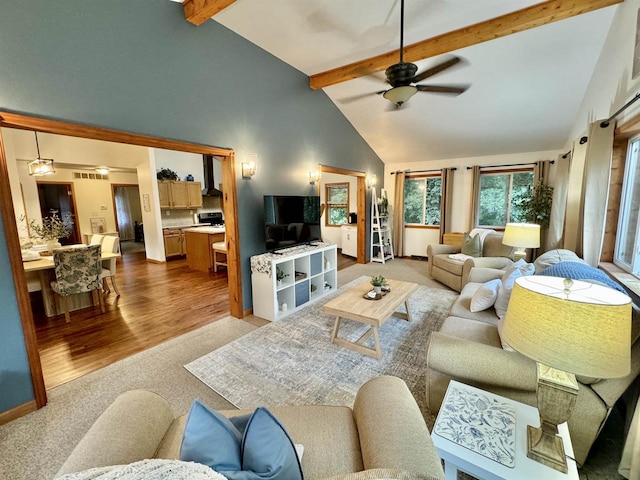 living room featuring ceiling fan, beamed ceiling, light wood-type flooring, and high vaulted ceiling