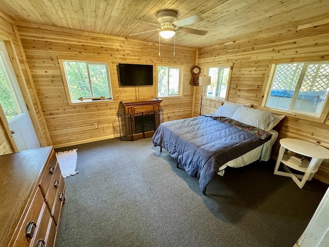 bedroom featuring wooden walls, wood ceiling, carpet flooring, and ceiling fan