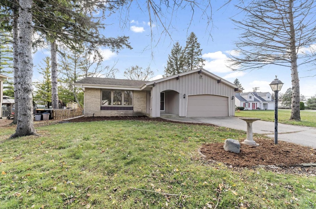 ranch-style house featuring a garage and a front yard