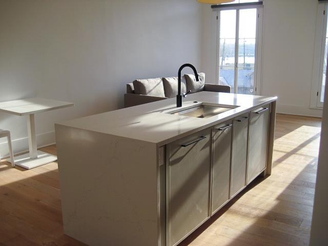 kitchen featuring light wood-type flooring, sink, and an island with sink