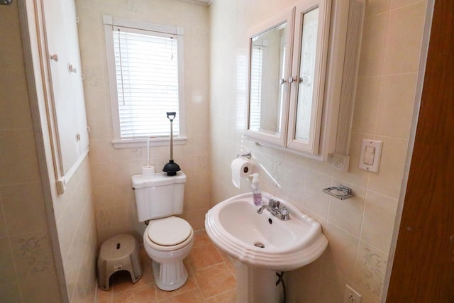 bathroom featuring sink, tile patterned floors, toilet, and tile walls