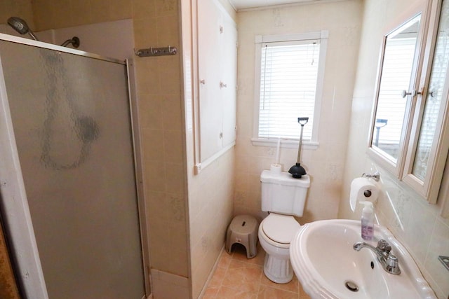 bathroom with tile walls, sink, tile patterned flooring, toilet, and a shower with shower door