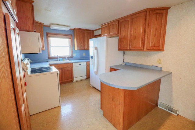 kitchen featuring kitchen peninsula, white appliances, and sink