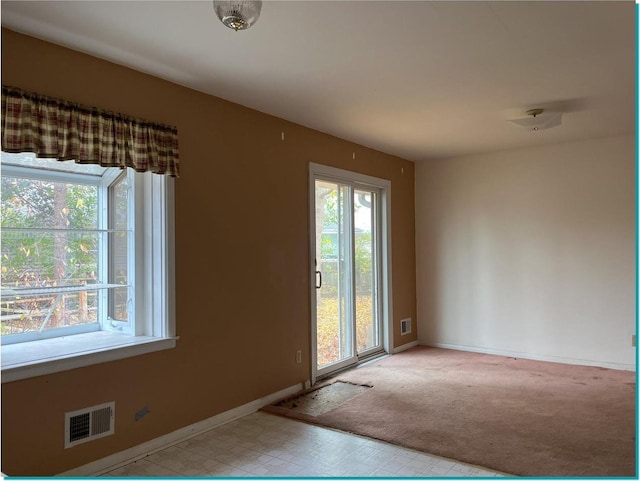 doorway with plenty of natural light and light colored carpet