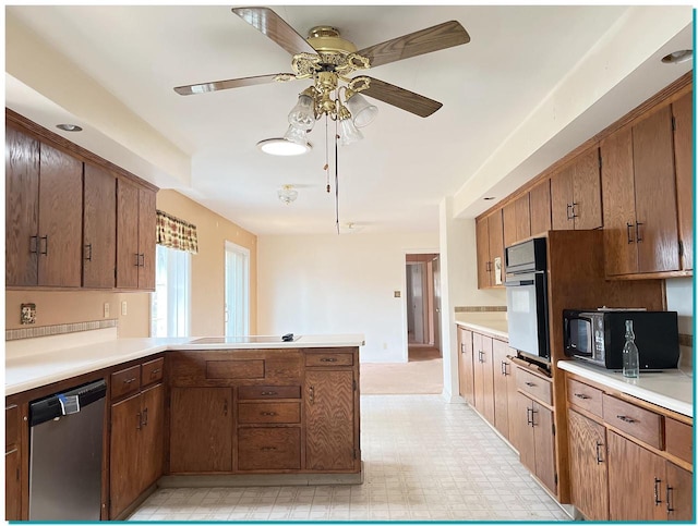 kitchen featuring stovetop, wall oven, dishwasher, kitchen peninsula, and ceiling fan