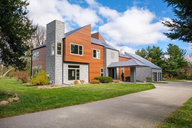 4720 Sumac Rd, Middleton, WI 53562 - view of front facade with stone siding, a chimney, a front yard, and driveway