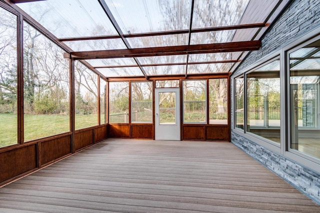 unfurnished sunroom featuring lofted ceiling with beams