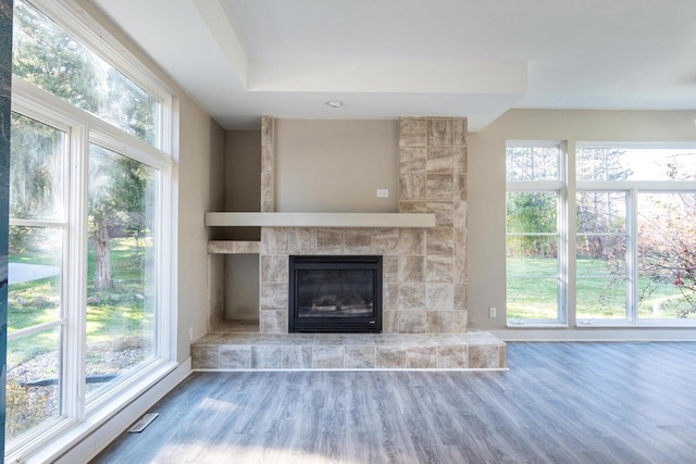 4720 Sumac Rd, Middleton, WI 53562 - unfurnished living room featuring wood finished floors, a tiled fireplace, and plenty of natural light