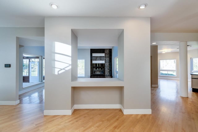 hallway featuring light hardwood / wood-style flooring, a healthy amount of sunlight, and built in features