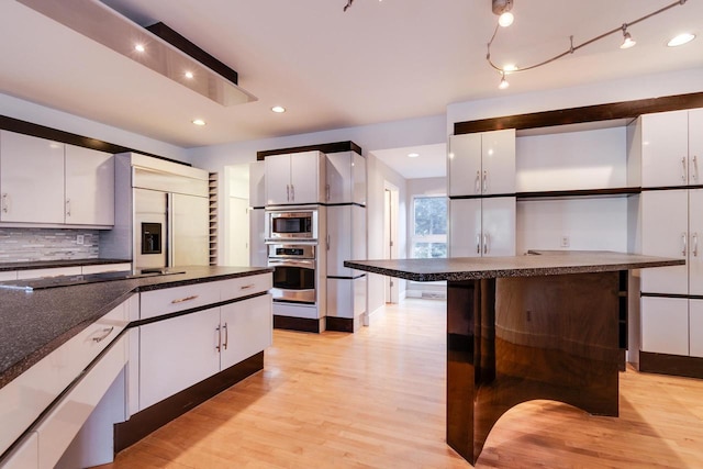 4720 Sumac Rd, Middleton, WI 53562 - kitchen with built in appliances, open shelves, dark countertops, white cabinetry, and decorative backsplash