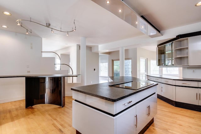 kitchen with a center island, white cabinets, light hardwood / wood-style floors, and plenty of natural light