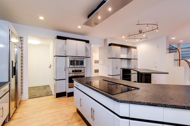 kitchen with light hardwood / wood-style flooring, white cabinets, white fridge, black electric stovetop, and a center island