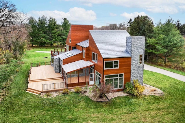 rear view of house with a wooden deck and a yard