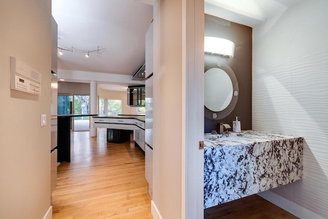 hallway featuring light hardwood / wood-style flooring and sink