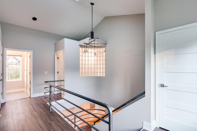 staircase with wood-type flooring and lofted ceiling