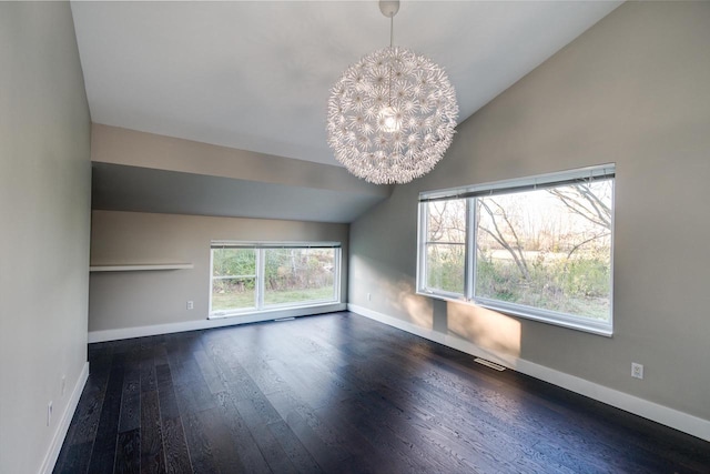 spare room with vaulted ceiling, plenty of natural light, and dark wood-type flooring