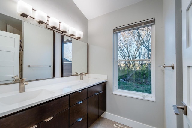 bathroom with vanity and lofted ceiling