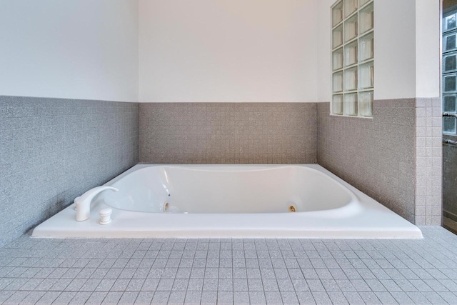 bathroom with a relaxing tiled tub