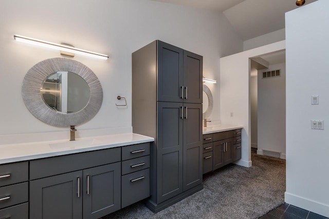 bathroom featuring vanity and lofted ceiling