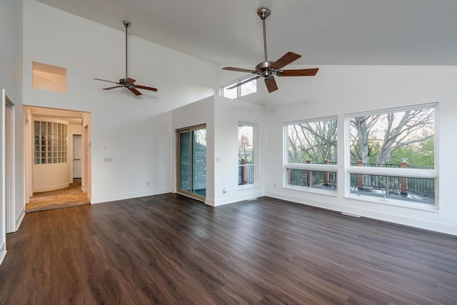 unfurnished living room featuring dark hardwood / wood-style floors, high vaulted ceiling, ceiling fan, and a healthy amount of sunlight