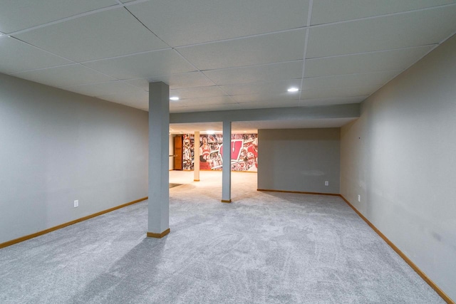 basement with a drop ceiling and carpet floors