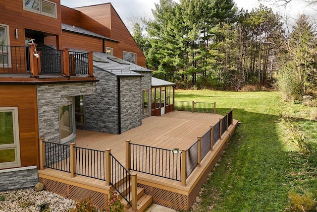 wooden deck featuring a lawn