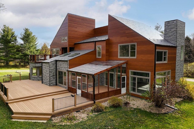 4720 Sumac Rd, Middleton, WI 53562 - rear view of house featuring a sunroom, a chimney, a wooden deck, stone siding, and a balcony