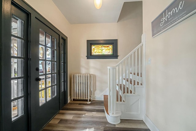 foyer entrance with radiator and hardwood / wood-style flooring