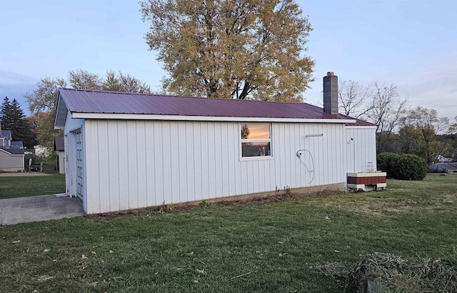 view of home's exterior with a yard and an outdoor structure