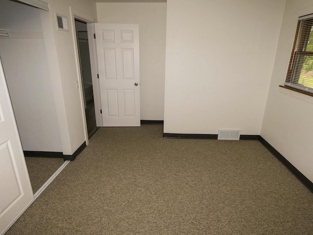 unfurnished room featuring dark carpet