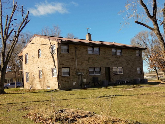 back of house featuring central AC unit and a yard