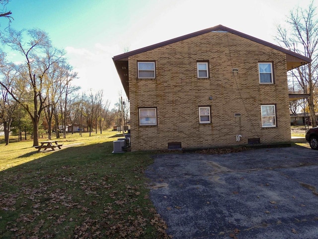 view of home's exterior featuring cooling unit and a yard