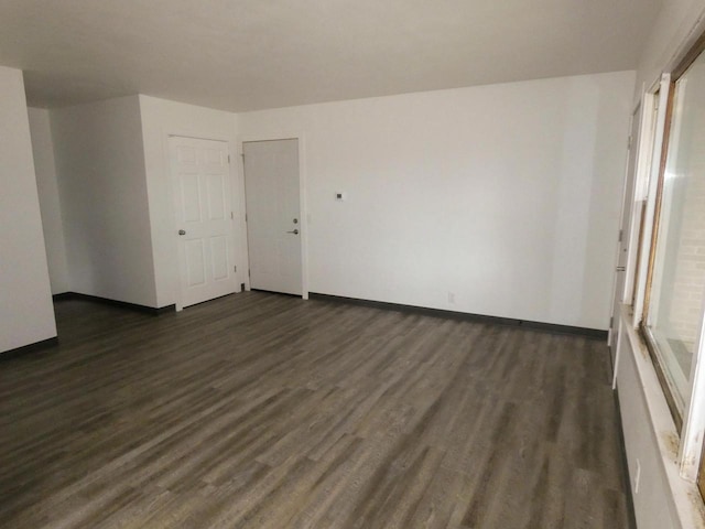 unfurnished room with dark wood-type flooring