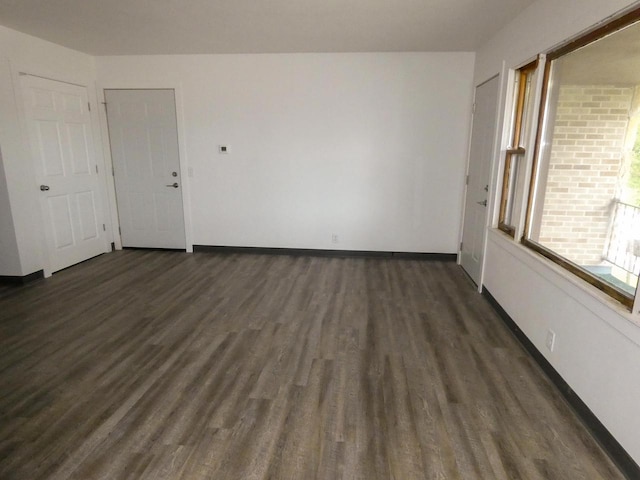 unfurnished room with dark wood-type flooring