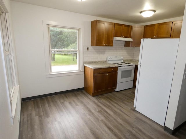 kitchen with tasteful backsplash, white appliances, and dark hardwood / wood-style floors