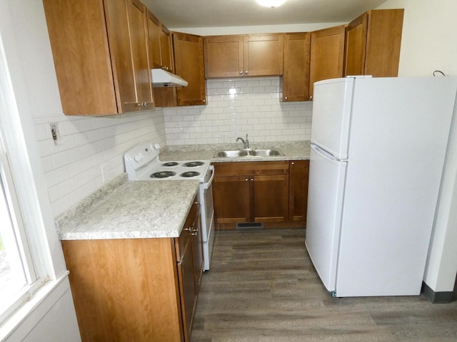 kitchen featuring dark wood-type flooring, white appliances, sink, and decorative backsplash