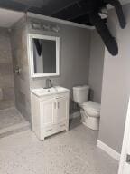 bathroom featuring toilet, vanity, and a tile shower