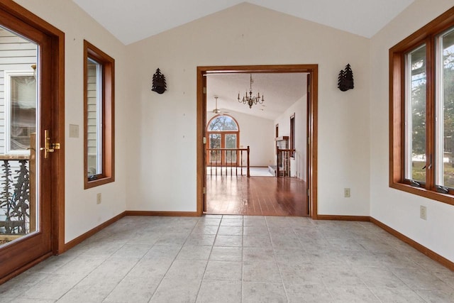 unfurnished room featuring light tile patterned floors, lofted ceiling, and an inviting chandelier