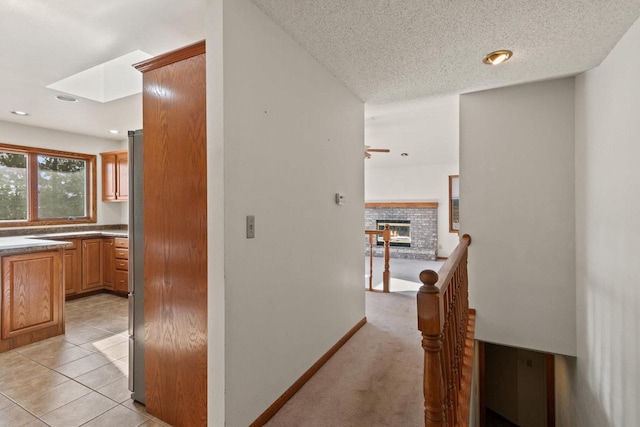 hallway featuring a textured ceiling and light tile patterned floors