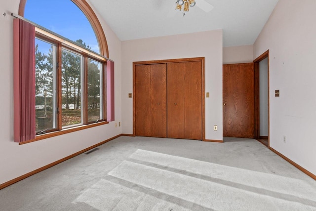 unfurnished bedroom with a closet, light colored carpet, and multiple windows