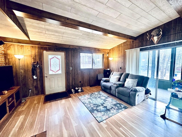 living room with beamed ceiling, light wood-type flooring, wooden walls, and wooden ceiling