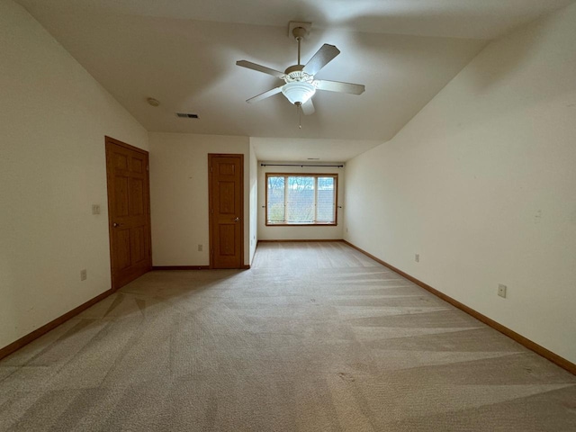 carpeted spare room featuring ceiling fan and lofted ceiling