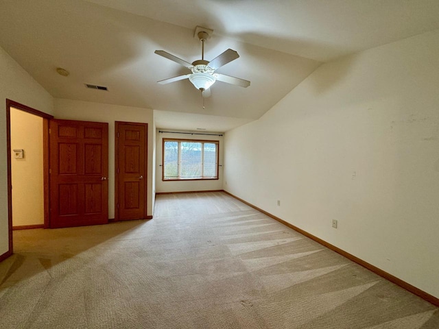 unfurnished bedroom with ceiling fan, light colored carpet, and vaulted ceiling